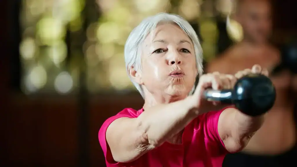 Older woman doing weight training Bridgend to help her strength and longevity 
